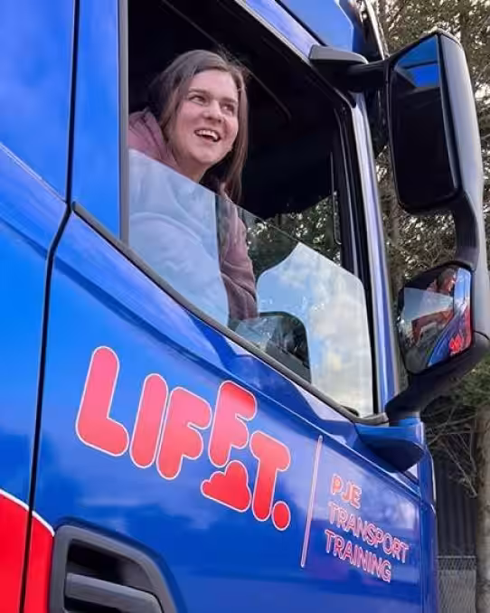 Image of Aimie sat in blue HGV after passing HGV training course with Lifft