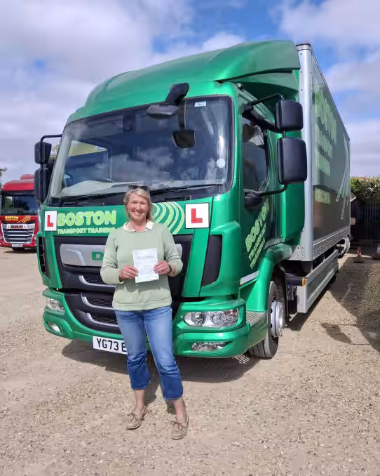 Image of Lindy in front of a green HGV after passing her HGV training course with Lifft