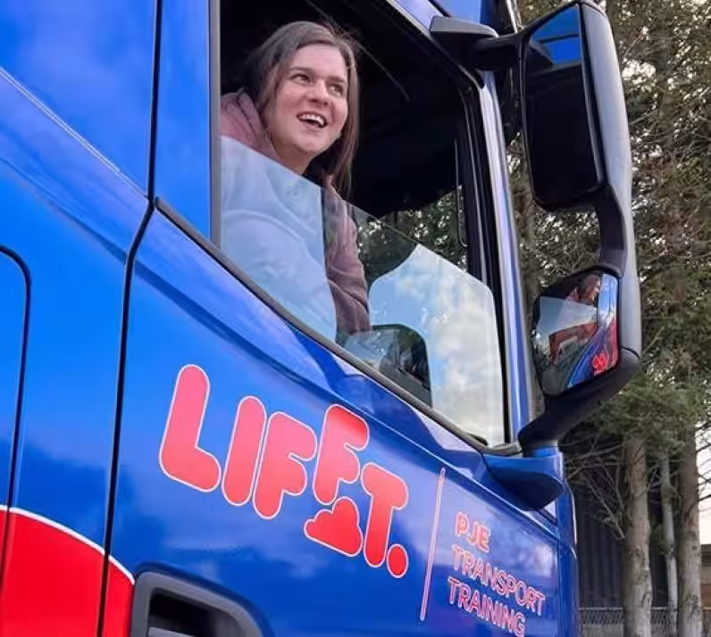 Image of Aimie sat in blue HGV after passing HGV training course with Lifft