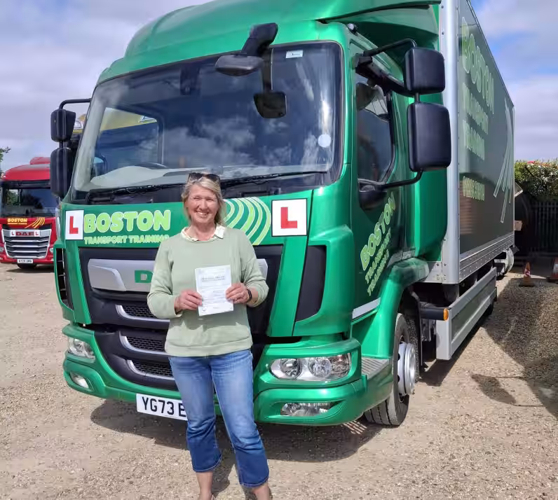 Image of Lindy in front of a green HGV after passing her HGV training course with Lifft