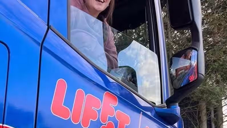 Image of Aimie sat in blue HGV after passing HGV training course with Lifft