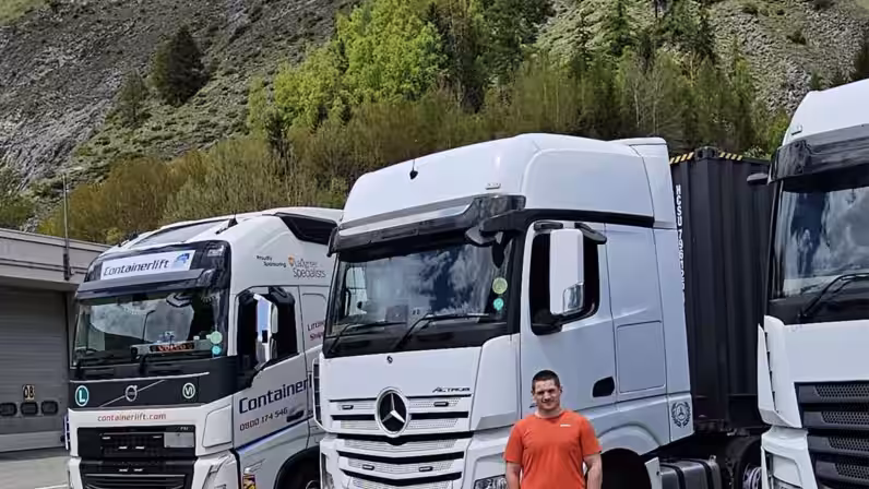 Image of Geoff stoof in front of white HGV's used in transport training